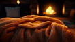 chunky knit blanket on a bed with a glowing fireplace in the background