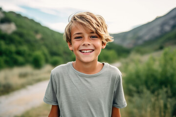 A young boy in a grey shirt smiles for the camera