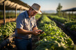 © Gonzalo - farmer using a smartphone app. smart farm concept