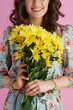 © Alliance - Closeup on smiling female in floral dress on pink