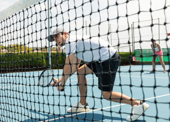 Wall Mural - Man on serve with tenis racket and dressed in white t-shirt, black shorts and white shoes.