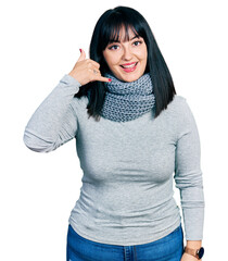 Sticker - Young hispanic plus size woman wearing winter scarf smiling doing phone gesture with hand and fingers like talking on the telephone. communicating concepts.