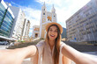 Selfie girl in Florianopolis, Brazil. Young tourist woman taking self portrait with Florianopolis Cathedral, Santa Catarina, Brazil.