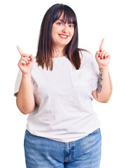 Canvas Print - Young plus size woman wearing casual clothes smiling confident pointing with fingers to different directions. copy space for advertisement