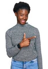 Canvas Print - Young african american girl wearing casual clothes cheerful with a smile of face pointing with hand and finger up to the side with happy and natural expression on face