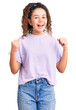 © Krakenimages.com - Beautiful kid girl with curly hair wearing casual clothes celebrating surprised and amazed for success with arms raised and open eyes. winner concept.