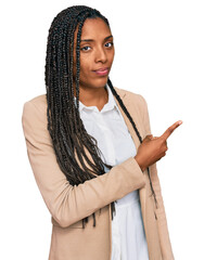 Wall Mural - African american woman wearing business jacket pointing with hand finger to the side showing advertisement, serious and calm face