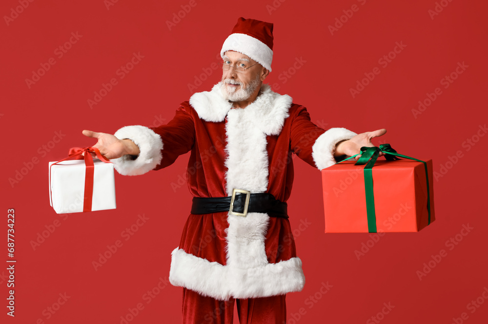 Cool Santa Claus with gift boxes on red background