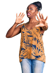 Canvas Print - Young african american woman wearing casual clothes afraid and terrified with fear expression stop gesture with hands, shouting in shock. panic concept.