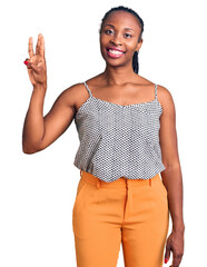 Wall Mural - Young african american woman wearing casual clothes showing and pointing up with fingers number three while smiling confident and happy.