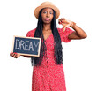 Young african american woman holding blackboard with dream word with angry face, negative sign showing dislike with thumbs down, rejection concept