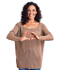 Wall Mural - Middle age beautiful woman wearing casual sweater smiling in love showing heart symbol and shape with hands. romantic concept.