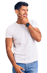 Sticker - Young latin man wearing casual clothes thinking worried about a question, concerned and nervous with hand on chin