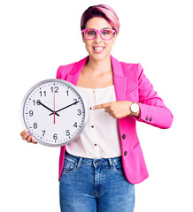 Sticker - Young beautiful woman with pink hair wearing business jacket and holding clock smiling happy pointing with hand and finger