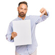 © Krakenimages.com - Handsome middle age man holding blank empty banner with angry face, negative sign showing dislike with thumbs down, rejection concept