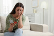 © New Africa - Stressed woman with credit card and smartphone at home. Be careful - fraud