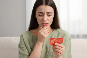 Canvas Print - Confused woman with credit card at home. Be careful - fraud