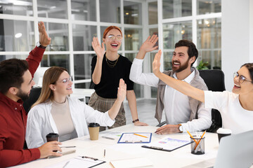 Sticker - Team of employees joining hands in office