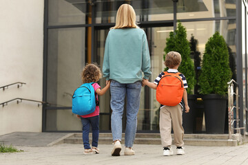 Sticker - Woman and her children on their way to kindergarten outdoors, back view