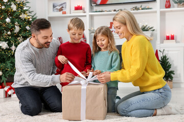 Wall Mural - Parents and their children opening Christmas gift at home