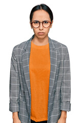 Wall Mural - Young hispanic girl wearing business jacket and glasses skeptic and nervous, frowning upset because of problem. negative person.