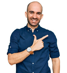 Wall Mural - Young hispanic man wearing casual clothes cheerful with a smile on face pointing with hand and finger up to the side with happy and natural expression