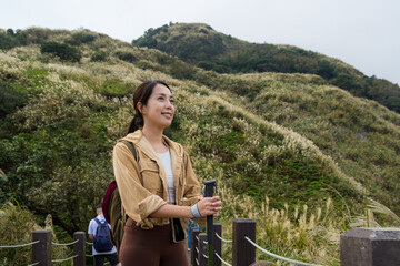 Canvas Print - Woman go hiking with trekking pole and walk though the mountain