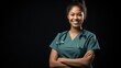 A Beautiful female nurse smiling with arms crossed looking at camera, side view, half body shot, black isolated background