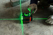 Worker wear glove and checks the floor level with a laser level meter on the cement walls in construction site.