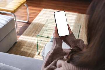 top view mockup image of a woman holding mobile phone with blank desktop white screen