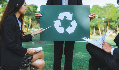 Group of businesspeople meeting at outdoor office in the nature planning and brainstorming on recycle strategy for greener environment by reducing and reusing recyclable waste. Gyre