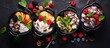 © AkuAku - Fresh fruit tubs with ice cream, chocolate, berries, nuts, scoop, on slate, top view, copy space.