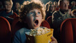 Surprised Boy with open mouth watching a horror movie at the cinema with popcorn. Childhood leisure activity concept