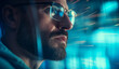 © GustavsMD - Attentive young business man software developer wearing glasses with reflection looking at computer screen developing code, programming or searching information working online, close up view.
