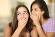 © Antonioguillem - Gossip woman telling secret to the ear to a friend