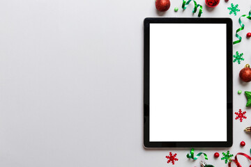 Wall Mural - Christmas online shopping from home tablet pc with blank white display top view. Tablet with copy space on colored background with Christmas decorations balls,. Winter holidays sales background