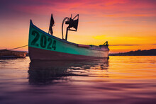 2024 Fishing Boat On Beach Shore And Sunset Reflection In Water 