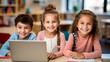 © MYDAYcontent - Diverse cheerful group of kids schoolchildren collaboratively using laptop in classroom seating around desk for learning