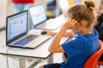 School children students using computers and coding at modern school