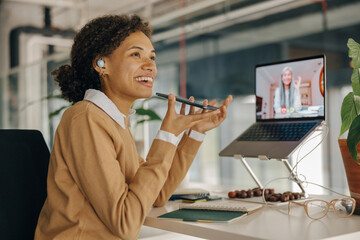 Wall Mural - Smiling business woman have video conference with client and record audio message sitting in office