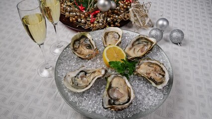 Wall Mural - Fresh oysters on ice rotating, Christmas New Year decoration, glasses of champagne. Close up