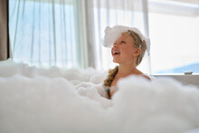 Smiling Girl Playing With Soap Suds In Bathtub