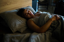 Young Woman Sleeping On Bed At Home