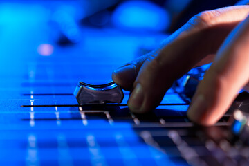 Close-up of a man's hand controlling a professional sound remote control.