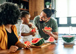 © Lumos sp - child family kitchen food boy son father mother watermelon fruit slice summer organic meal fun preparing healthy diet eating home black