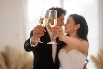 Wall Mural - Bride and groom holding glasses of champagne at the wedding ceremony