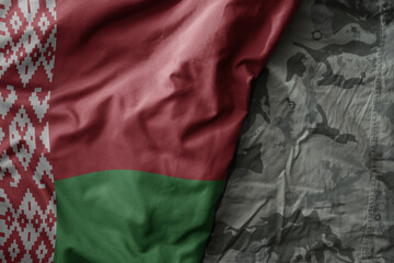 Wall Mural - waving flag of belarus on the old khaki texture background. military concept.