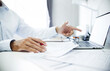 © Lek - Close-up shot, businessman or lawyer holding pen reviewing documents and contact customer via laptop to give advice about business contracts and various important documents for start new business