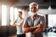 pretty confident older man smiling looking at camera in gym