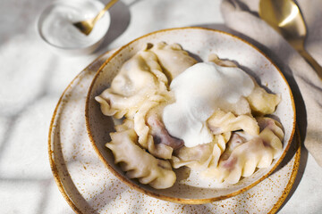 Wall Mural - Dumplings with cherries with sour cream and sugar. Traditional dish of Russian, Ukrainian, Belarusian cuisine known as Vareniki